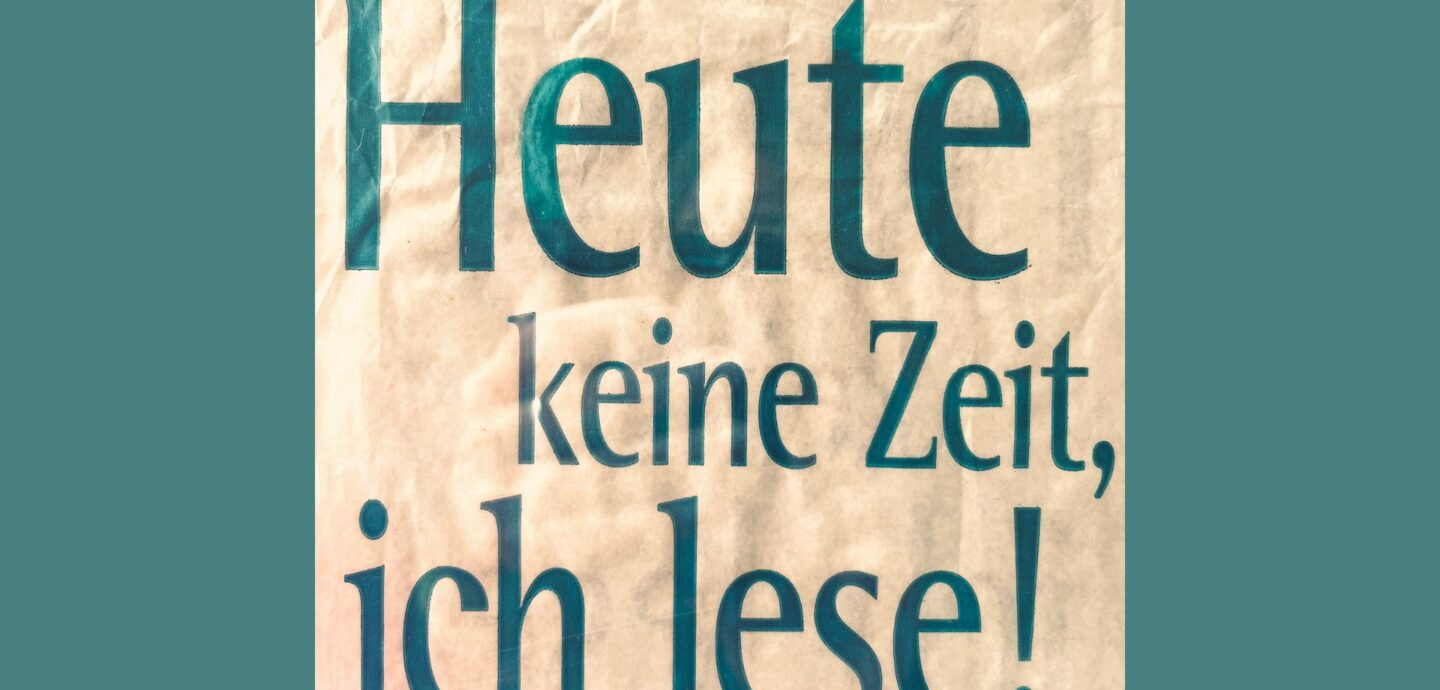 "Heute keine Zeit, ich lese", grüne Schrift auf cremefarbenem Papier vor dunkelgrünem Hintergrund